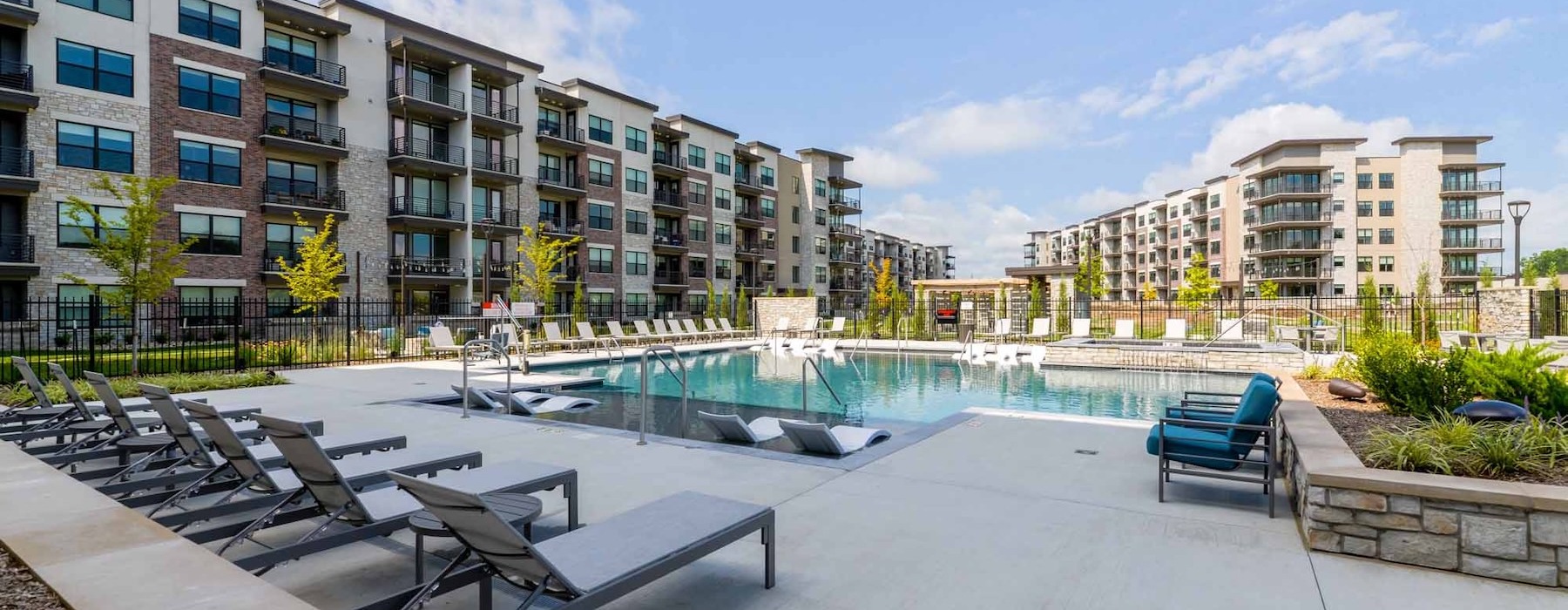 a pool with benches and a building in the background