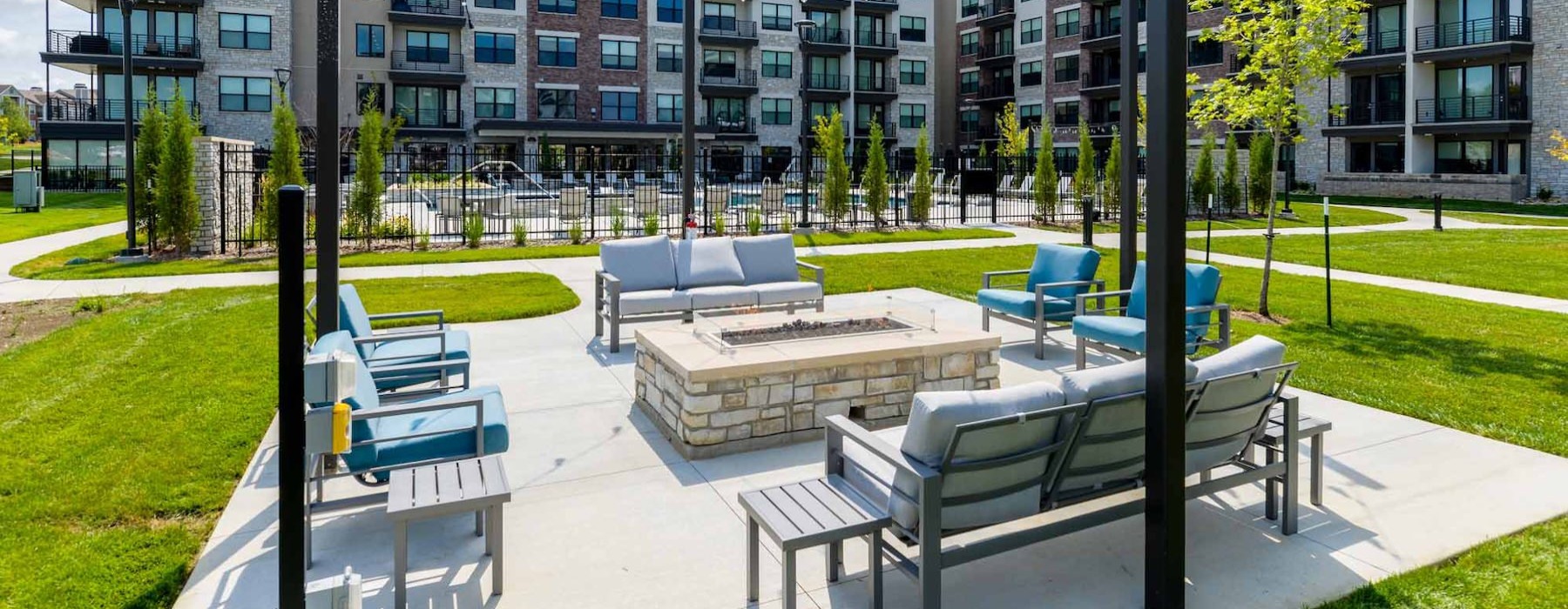 an outdoor lounge with a fire pit, couches and chairs